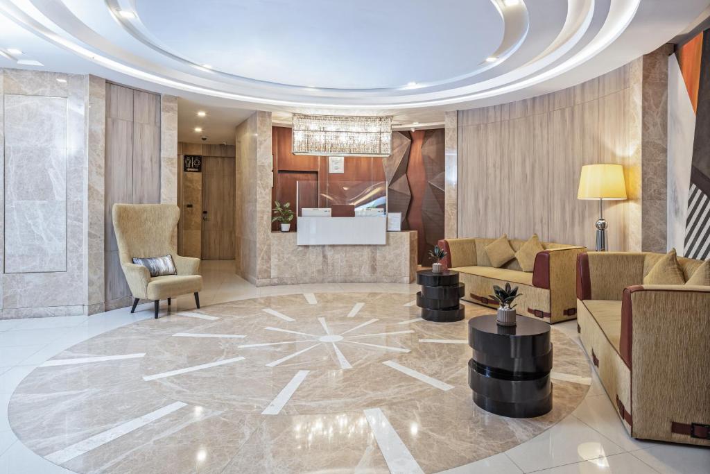 A polished lobby lounge with marble finishes, reception, and upholstered seating.
