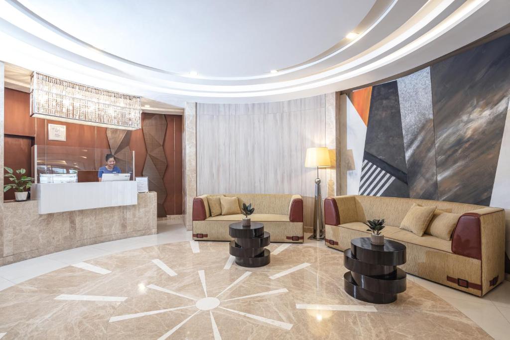 A polished reception lobby with sofas, lounge tables and geometric marble flooring.