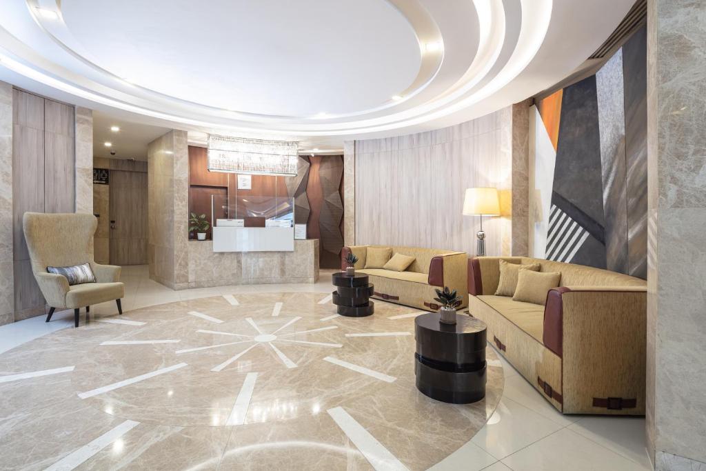 A broad view of the lobby’s curved sofas, reception desk and illuminated ceiling.