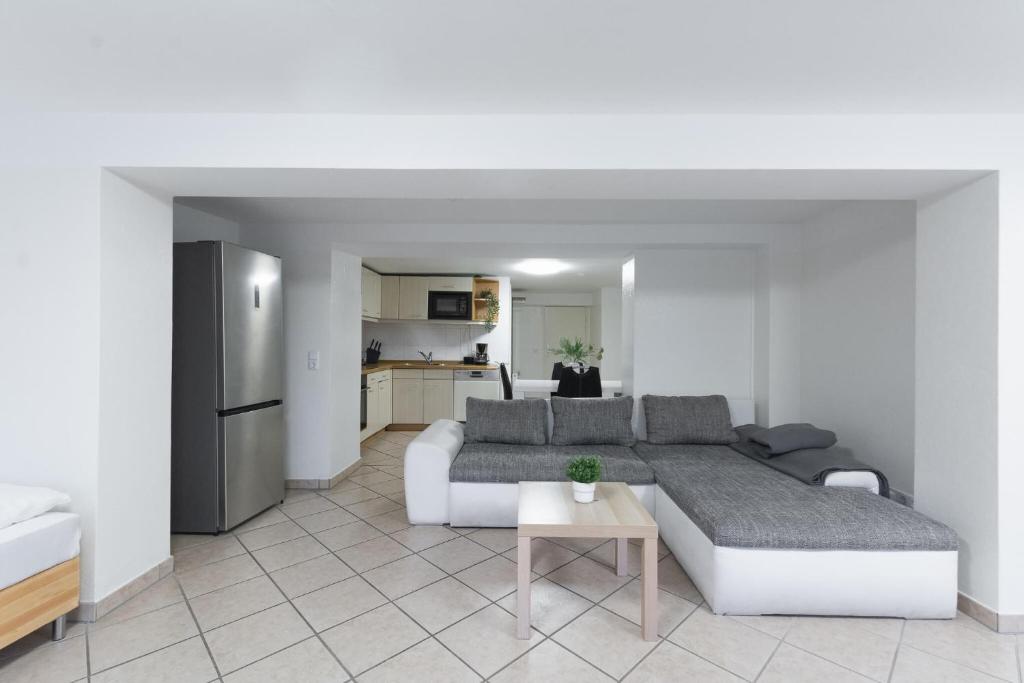 a living room with a couch and a kitchen at T&K Apartments - Dusseldorf - 2 rooms - Ground floor in Düsseldorf