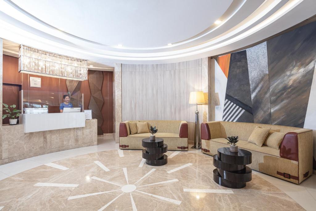 A polished lobby with a staffed reception desk and lounge seating.