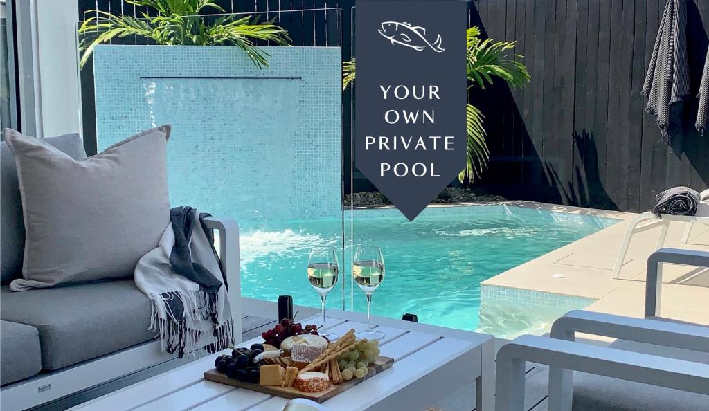 a table with a plate of food next to a pool at Bellbry Lodge in Trinity Beach