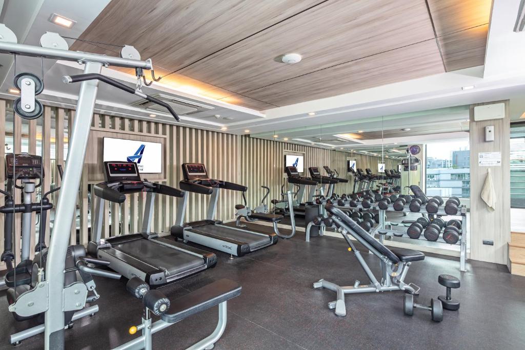 A cardio-and-weights gym with treadmills, a cable station and mirrored walls.