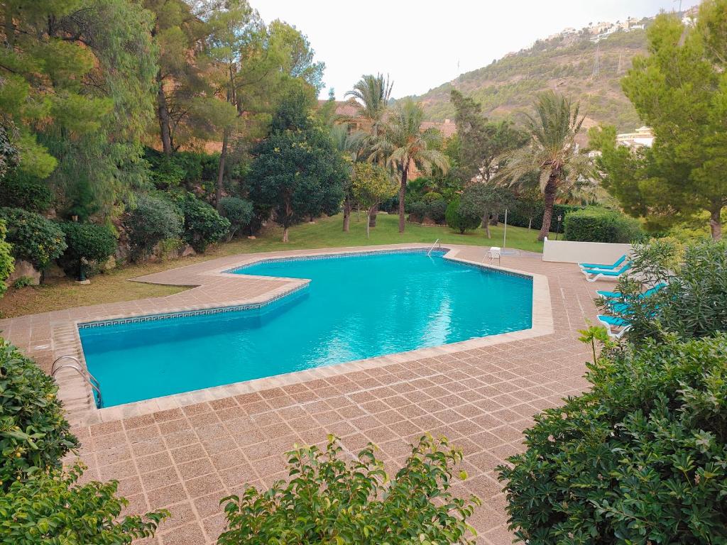 a swimming pool with blue water in a yard at Luxury Apartments Mascarat in Altea