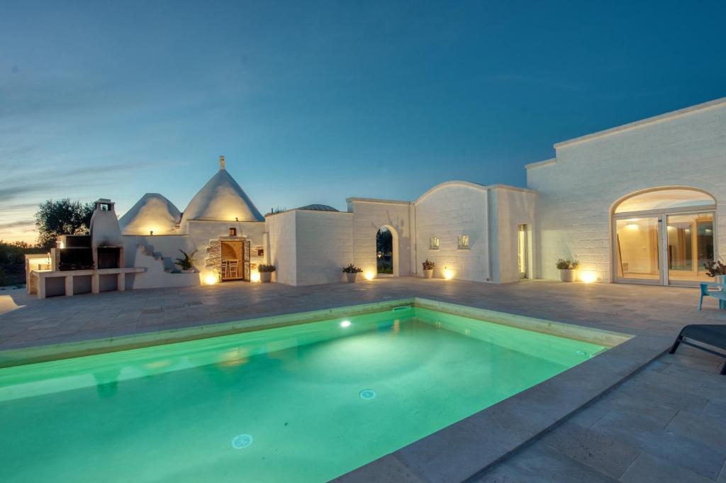 une piscine devant une maison dans l'établissement Trullo Amelie, à Ostuni
