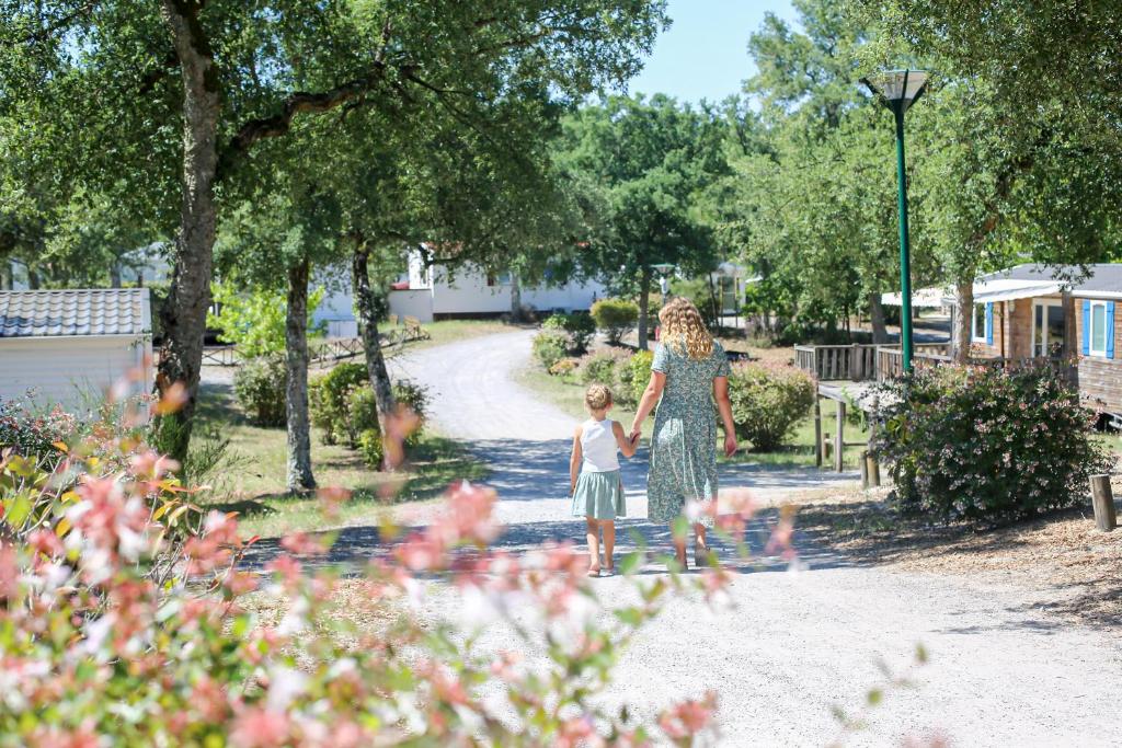 une femme et un enfant se promenant dans un parc dans l&#39;établissement Camping Nature L&#39;Airial, à Soustons