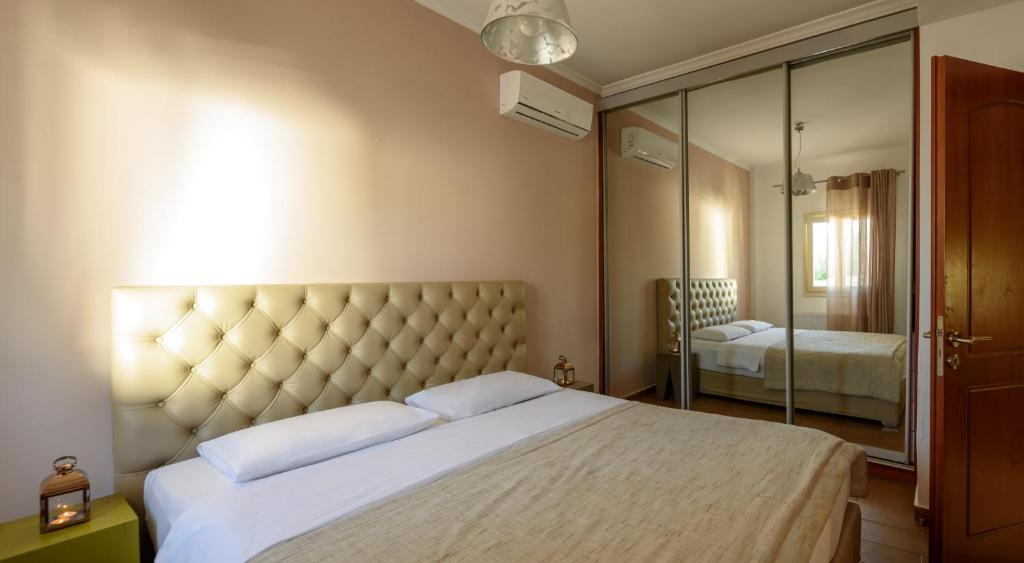 a bedroom with a large bed and a mirror at Suite Home Santorini in Fira