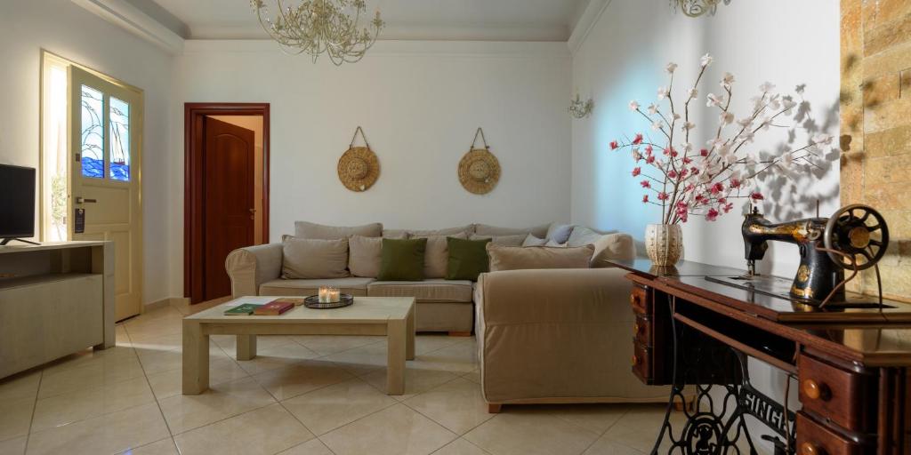 a living room with a couch and a table at Suite Home Santorini in Fira