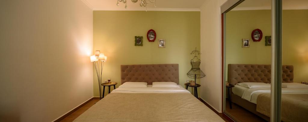 a bedroom with two beds and a mirror at Suite Home Santorini in Fira