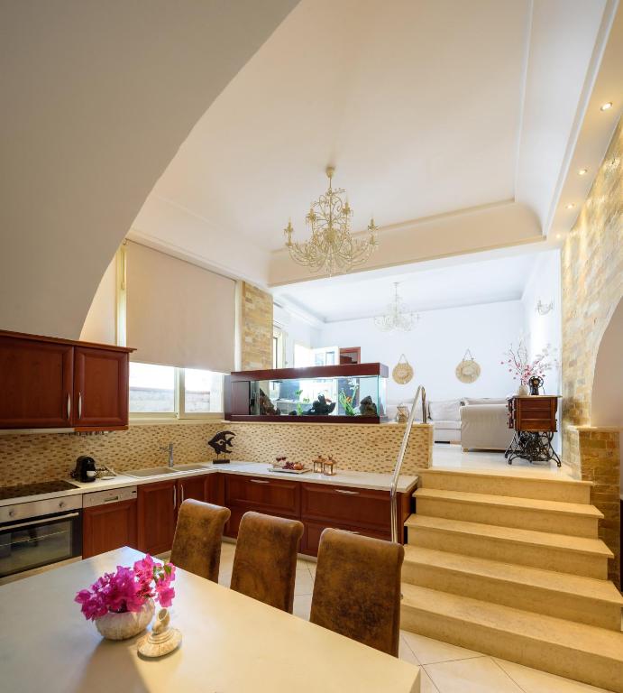 a kitchen with stairs and a table with purple flowers on it at Suite Home Santorini in Fira