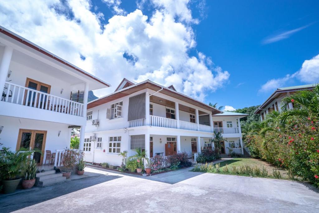 an exterior view of a white house at La Maison Hibiscus Self Catering Accommodation in Beau Vallon