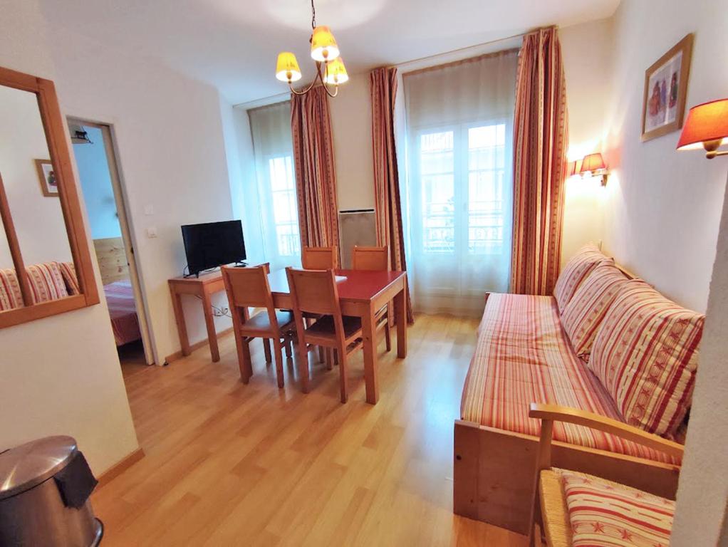 sala de estar con sofá y mesa en Val de Jade, Oo, T2, centre Luchon, wifi, casier à skis, 4 personnes, en Luchon