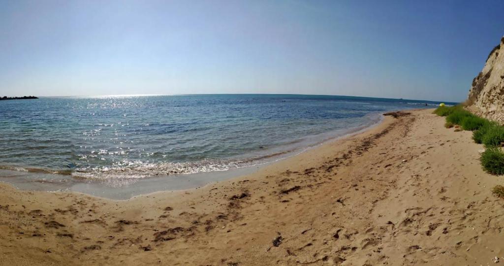 a sandy beach with the ocean in the background at Тузлата пентхаус / Tuzlata penthouse in Balchik