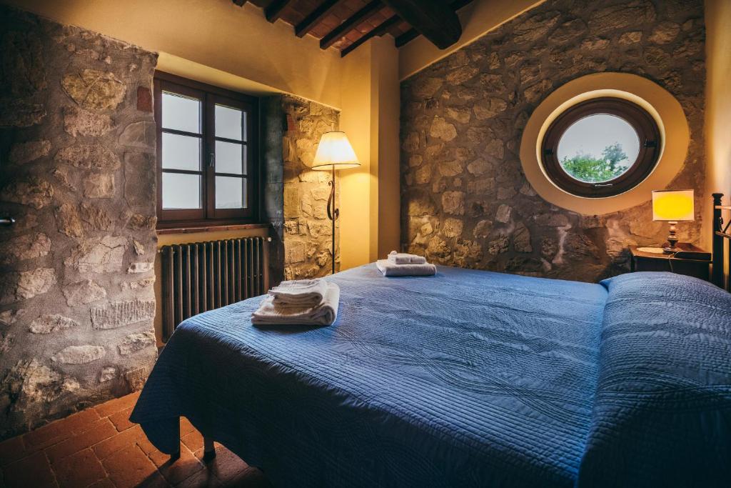 a bedroom with a blue bed and a round window at Casa Vacanza La Pozza in Molazzana