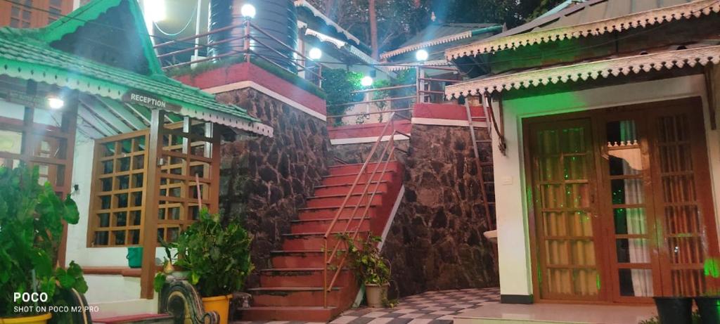 a building with red steps and a green door at Periyar Huts in Thekkady
