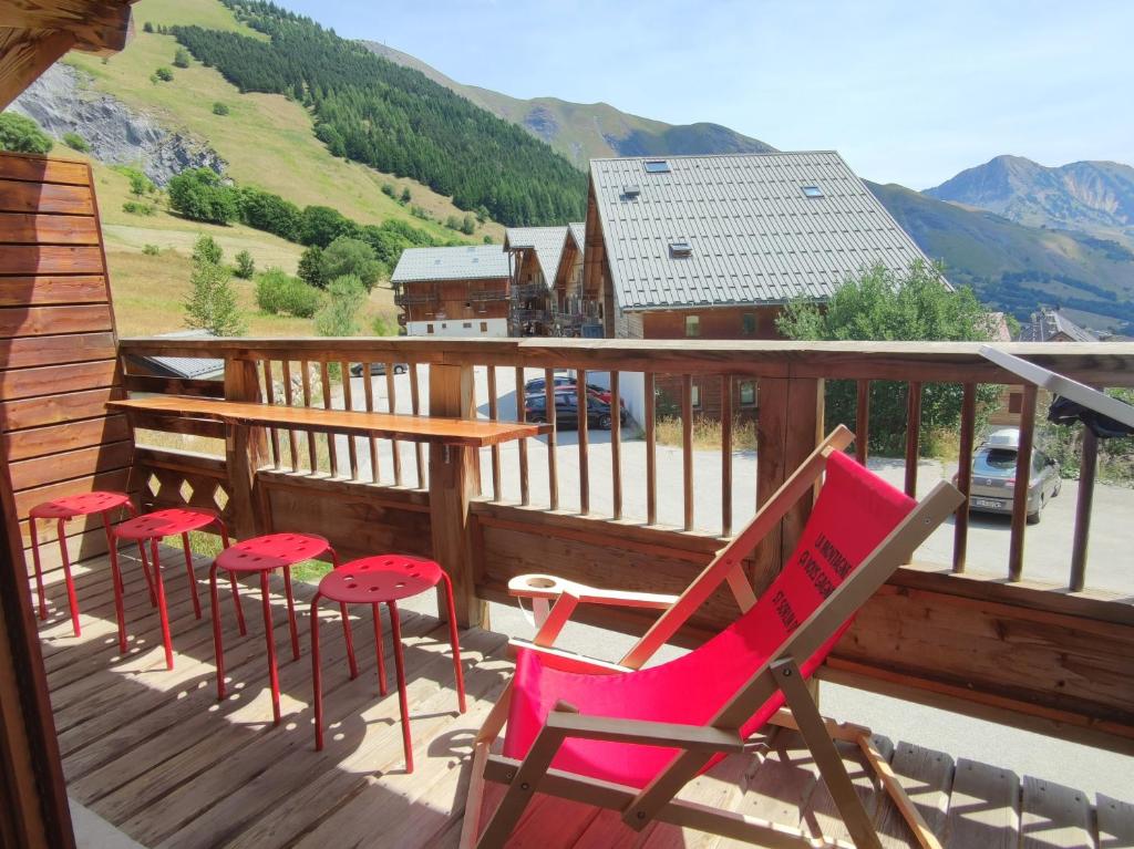 a deck with chairs and tables and a view of a mountain at Les Marmottes- 35 Appart Lumineux- 5 pers in Saint-Sorlin-dʼArves