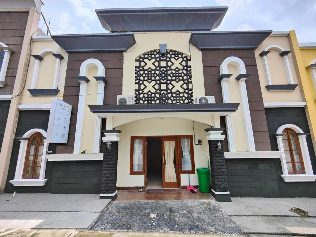 a house with a black and white at Adiputra Guesthouse 2 by HomiQ in Ngabean