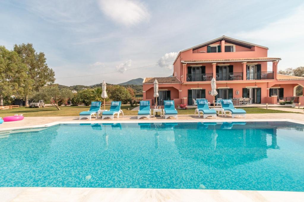 a villa with a swimming pool in front of a house at Eleni Luxury Villa in Almiros Beach