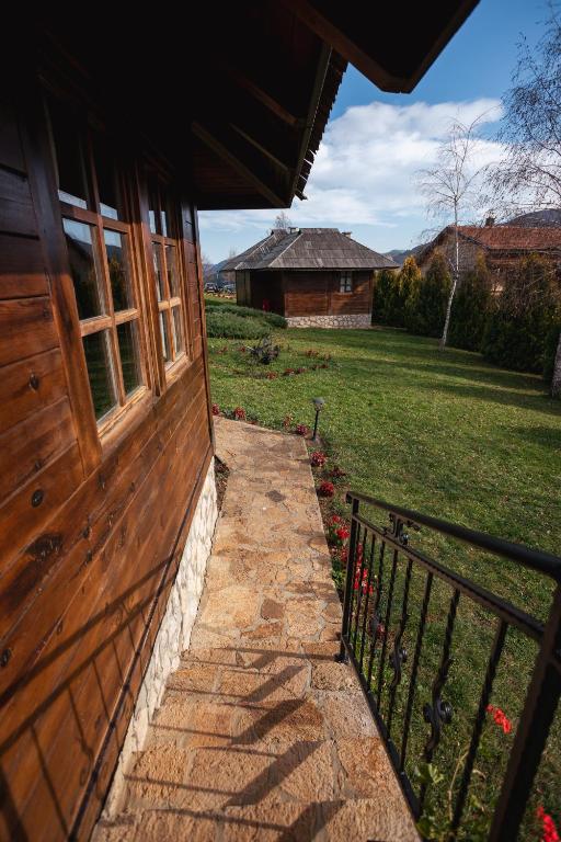 a building with a door and a fence next to a yard at ETNO SELO VRANEŠA Zlatar in Nova Varoš