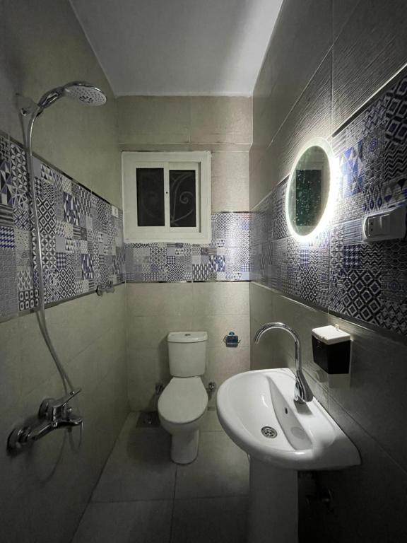 y baño con aseo y lavamanos. en Hotel unit in downtown Cairo for rent en El Cairo