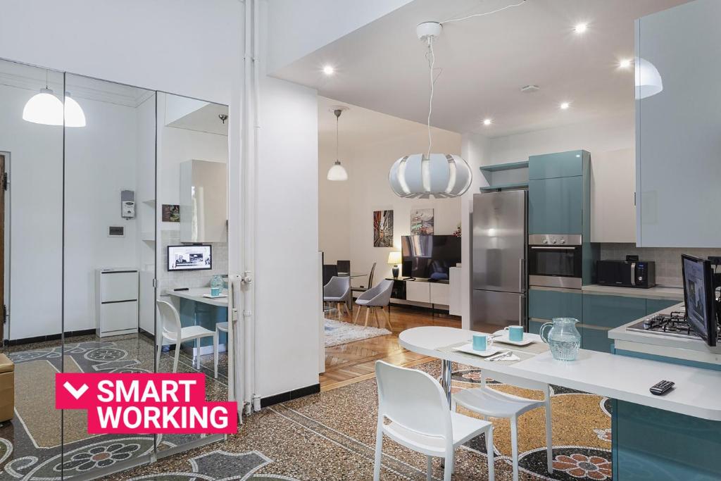 a kitchen and living room with a white table and chairs at Natty Family Apartment in Carignano by Wonderful Italy in Genova