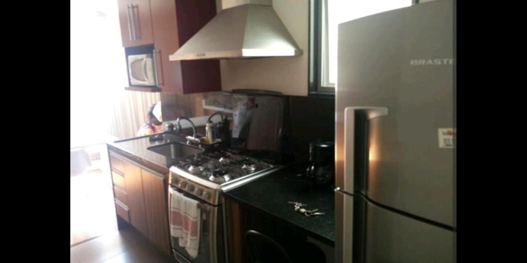 een keuken met een koelkast en een fornuis bovenste oven bij Designer Apartment Leme in Rio de Janeiro