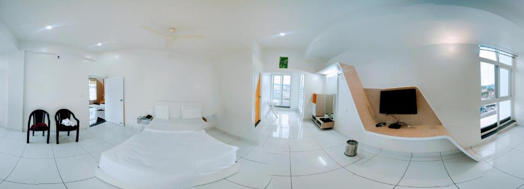 a white room with a staircase and a television at The Cocoon in Gonikoppal