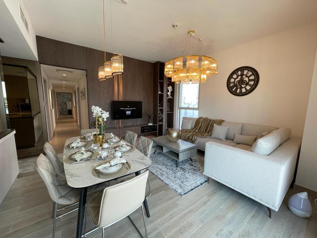 uma sala de estar com uma mesa e um sofá em Smart Living Apartment em Abu Dhabi