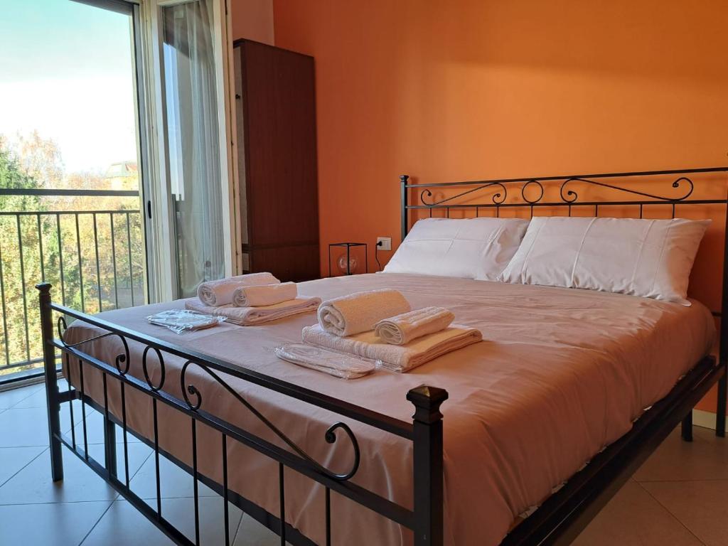 1 dormitorio con 1 cama con toallas en Navili Grand Apartment, en Trezzano sul Naviglio