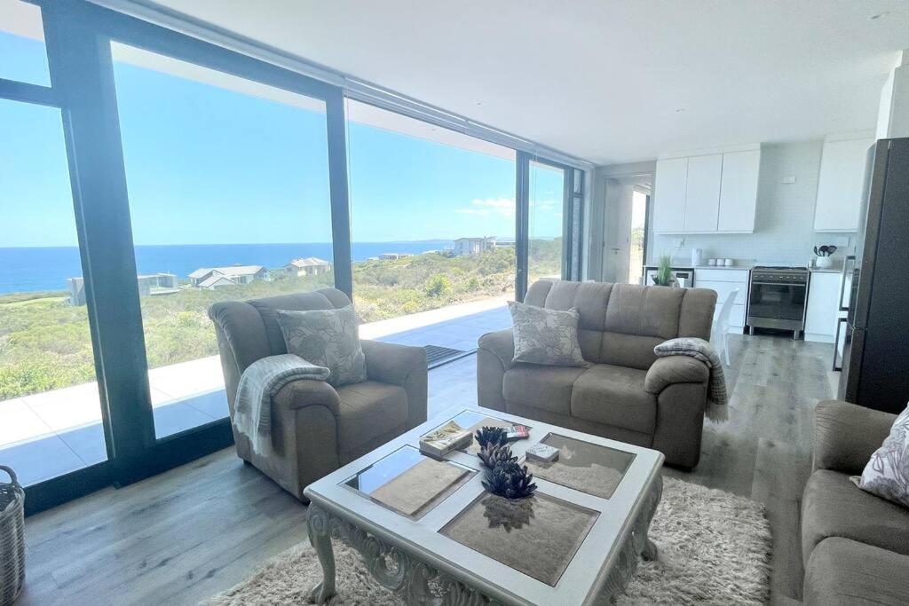 a living room with a view of the ocean at Exclusive luxury & lifestyle suite in Mossel Bay