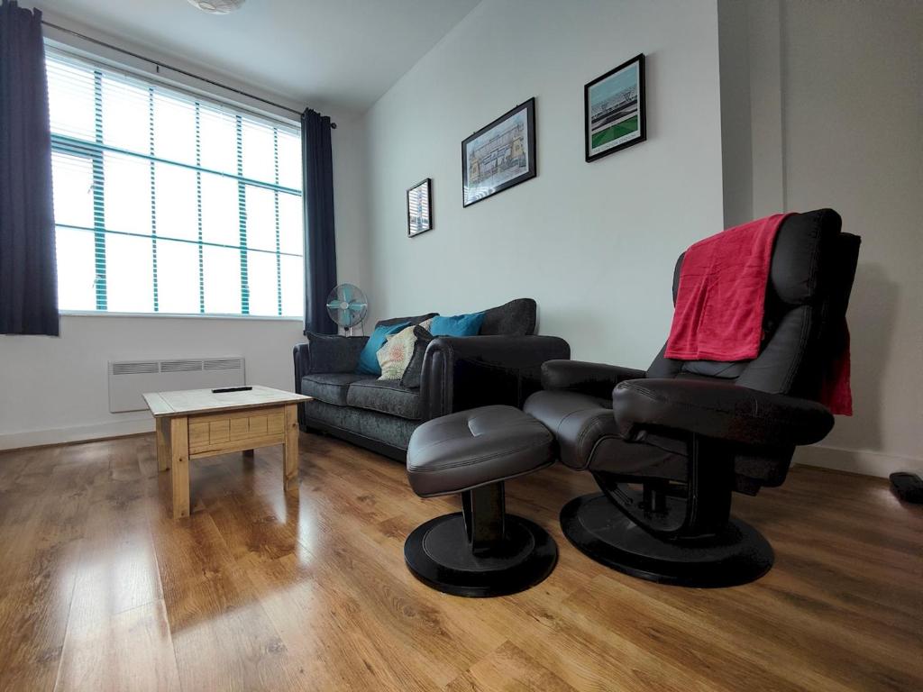 a living room with a chair and a couch at Pass the Keys Spacious Apartment Minutes to Birmingham Centre in Birmingham