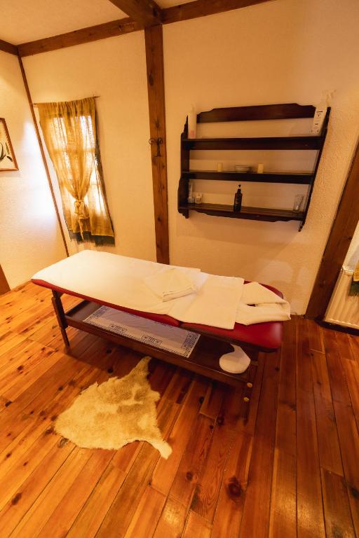a bed in a room with a wooden floor at ETNO SELO VRANEŠA Zlatar in Nova Varoš