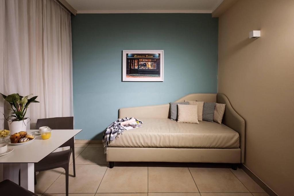 a bed in a room with a table and a tableablish at 115 The Strand Hotel by NEU Collective in Il-Gżira