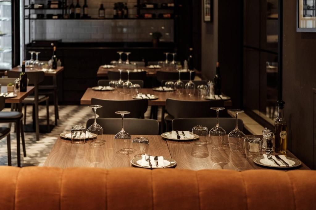 a long table in a restaurant with glasses and napkins at 115 The Strand Hotel by NEU Collective in Il-Gżira
