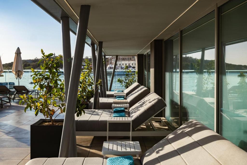 a balcony with couches and a view of the water at 115 The Strand Hotel by NEU Collective in Il-Gżira