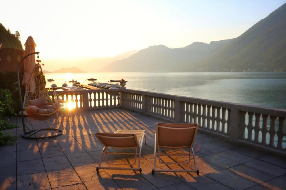 a balcony with chairs and a view of a lake at Ortensie & Oleandri al Lago - by MyHomeInComo in Argegno
