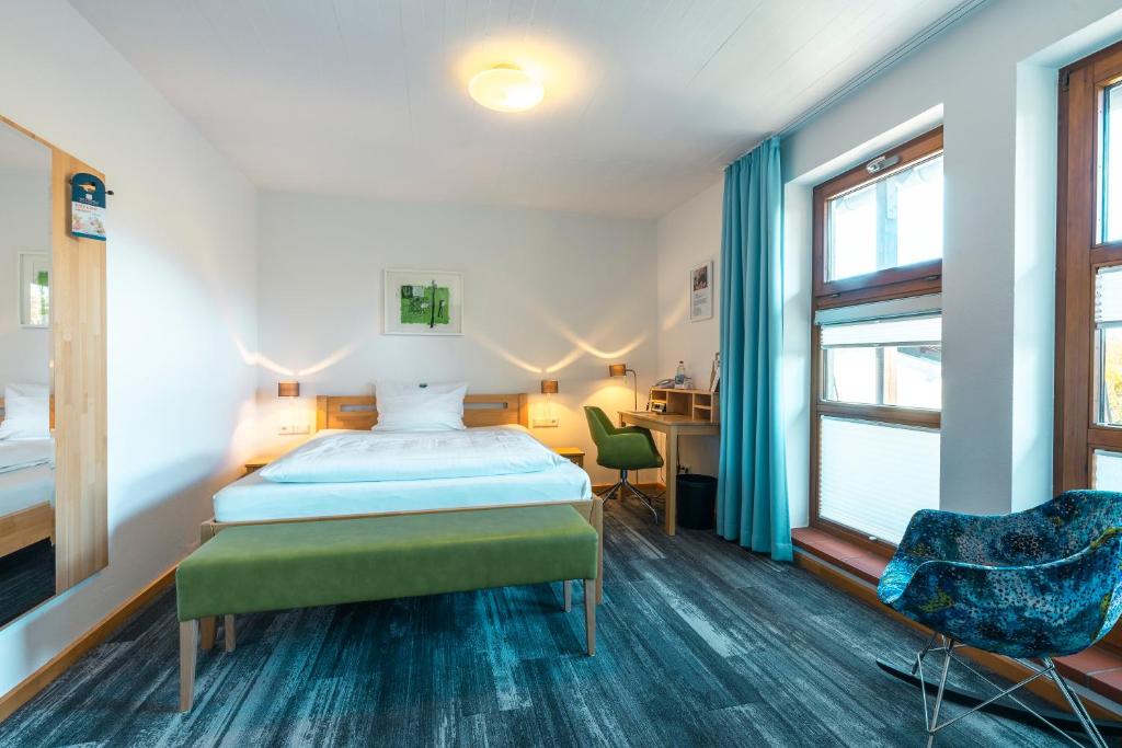 プフォルツハイムにあるHohenwart Forumのベッドルーム1室(ベッド1台、デスク、窓付)
