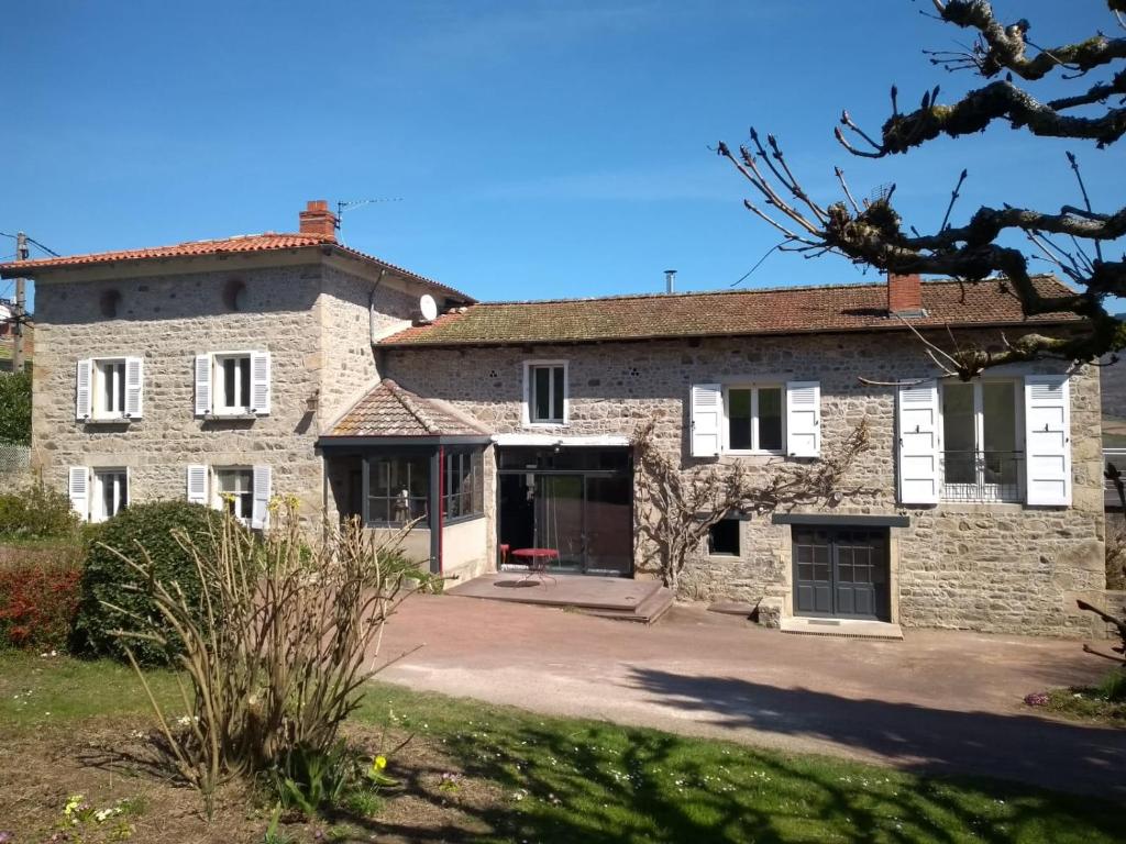vistas al exterior de una gran casa de piedra en Détour en Beaujolais en Les Ardillats