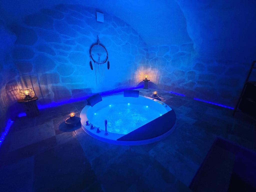 uma grande banheira num quarto com luzes azuis em The Dream Spa 07 em Tournon-sur-Rhône