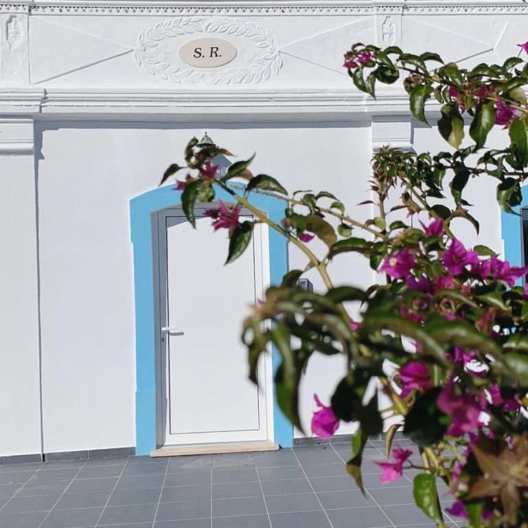 een kamer met een deur en een plant met paarse bloemen bij Summer Reference in Tavira