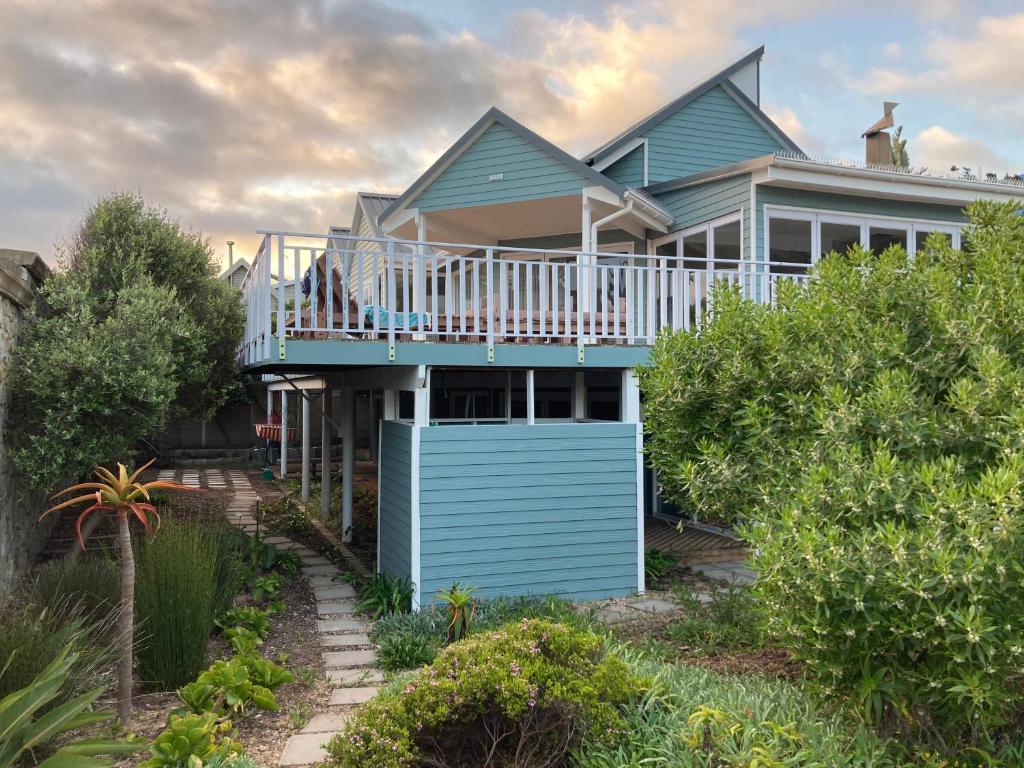een blauw huis met een veranda en een terras bij Glentana Beach Rental in Groot Brak Rivier