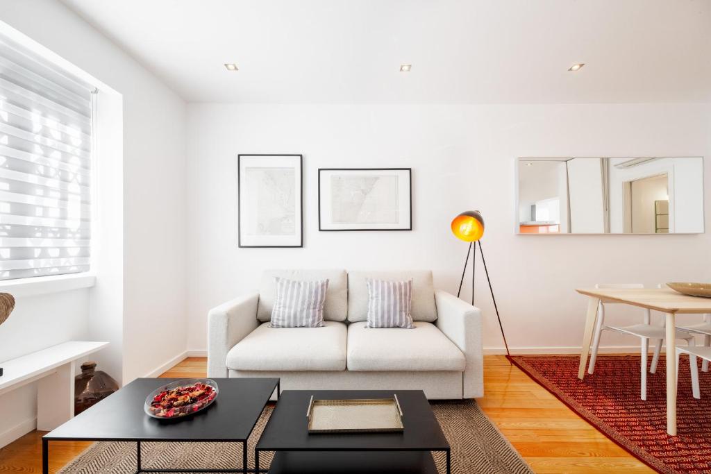 a living room with a white couch and a table at Navegantes Townhouse by Olala Homes in Cascais