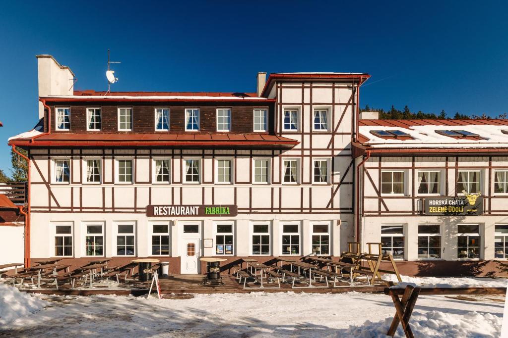 a large building with snow in front of it at Horská chata Zelené Údolí in Abertamy