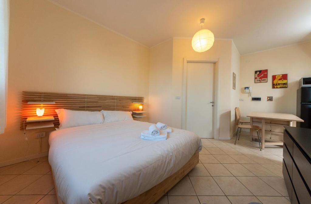 1 dormitorio con 1 cama blanca grande y escritorio en HouSmart San Lazzaro Salvo D'Acquisto 16, en San Lazzaro di Savena