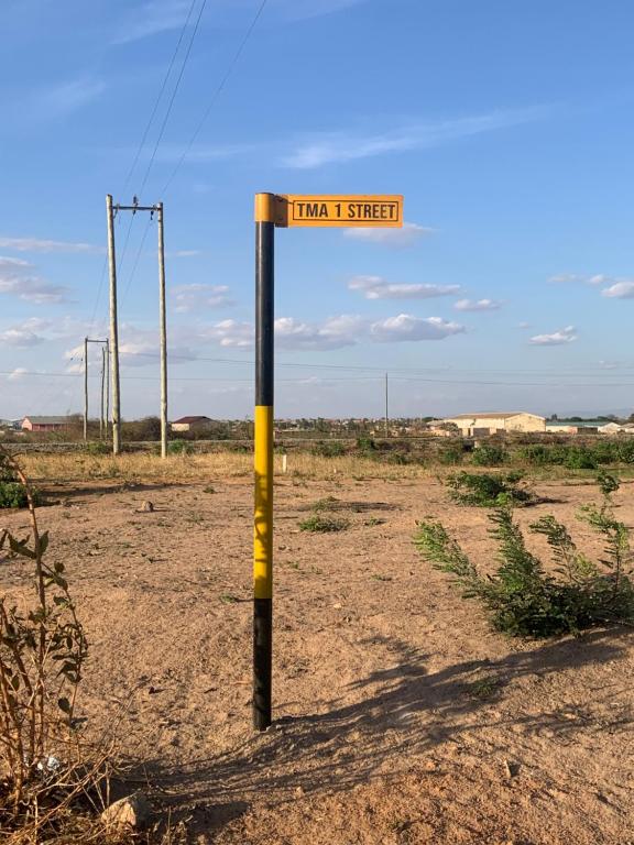 ein Straßenschild mitten auf einem Feld in der Unterkunft Dodoma, Tukae Inn in Dodoma