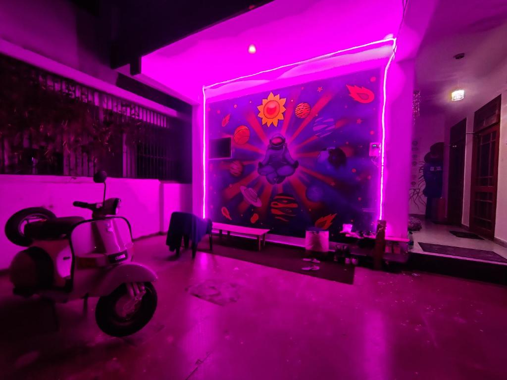 une chambre violette avec un scooter dans l'établissement Space house hostel, à Rishikesh