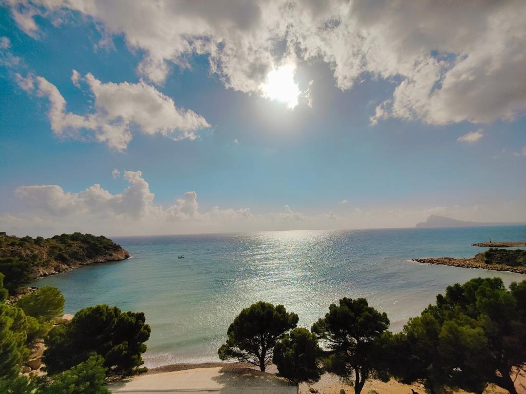 a view of a beach with the sun in the sky at Luxury Apartments Mascarat in Altea