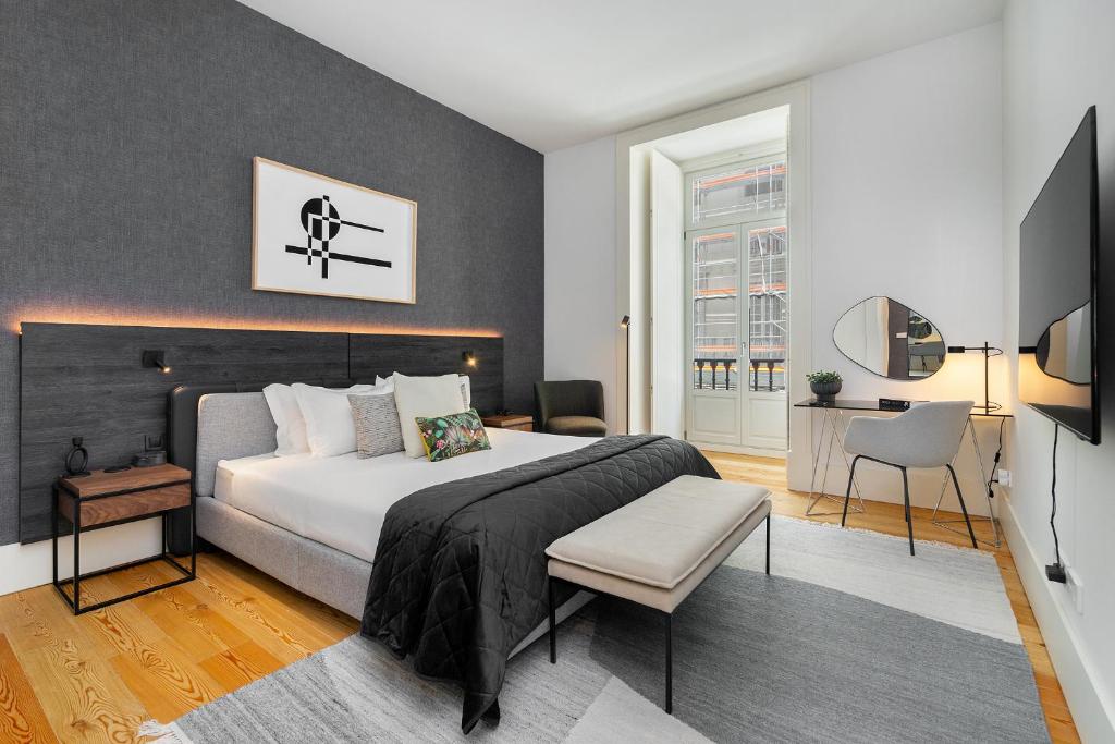 Schlafzimmer mit einem Kingsize-Bett und einem Schreibtisch in der Unterkunft WHome Prime Location Contemporary Luxury Apartment w/ AC & Elevator in Lissabon