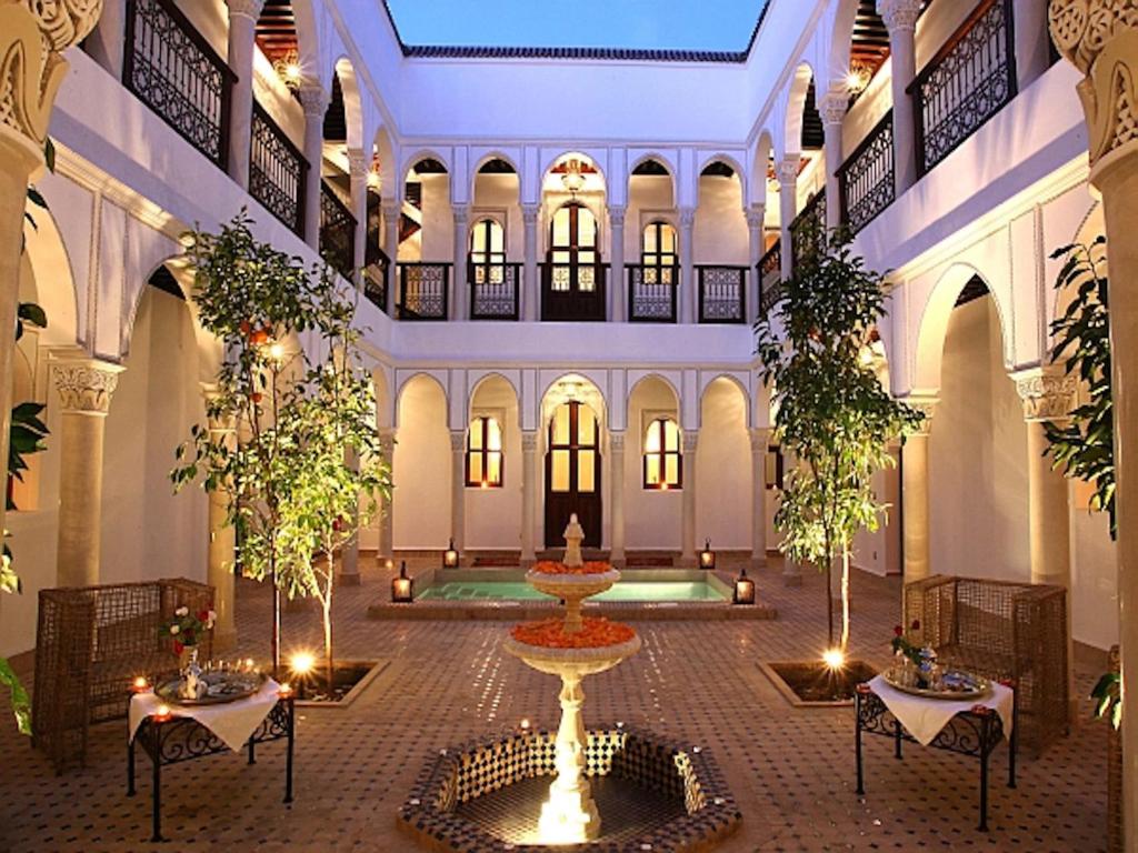 a courtyard with a fountain in the middle of a building at Riad Le Jardin d'Abdou in Marrakech