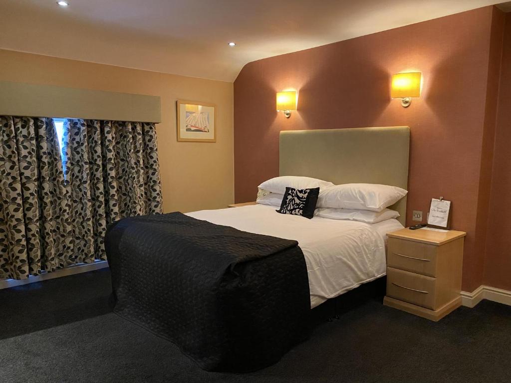 a bedroom with a large bed and a window at The Windmill Inn 